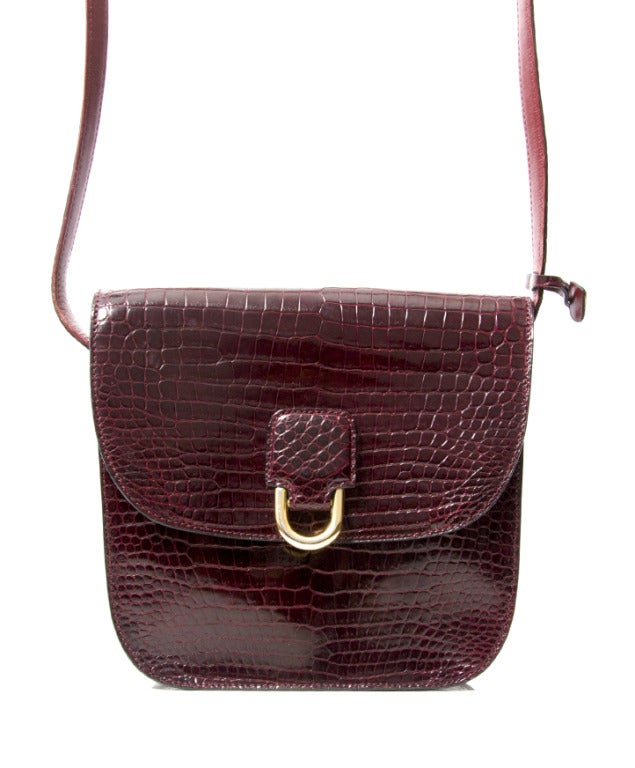 Lovely Delvaux shoulder bag that can also be worn cross body when desired. The bag is made from premium crocodile hide dyed an elegant burgundy hue. 
Has gold metal hardware throughout. Comes in its original dustbag and with matching pocket mirror.