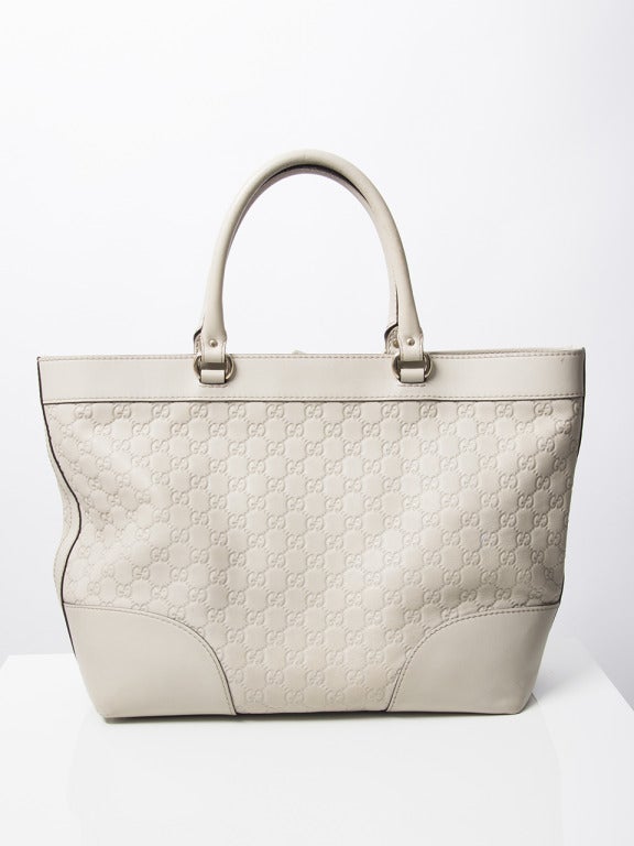 Gucci white monogram handbag with silver hardware and finished with dark brown leather stitching. One inside pocket with zipper. From the leather you can see that the bag has been worn. 

Handle drop:
6,5