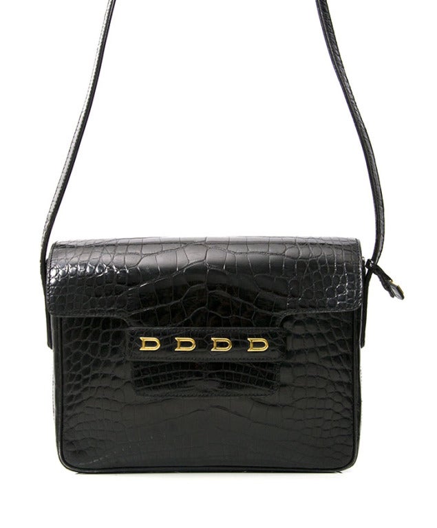 Beautiful Bandoulière bag by Delvaux. Made from real crocodile hide. Features 4 gold 'D's on the front flap. Flap closes with hidden push button with adjustable strap. 

Dimensions: 
23cm x 18cm x 5cm 
9