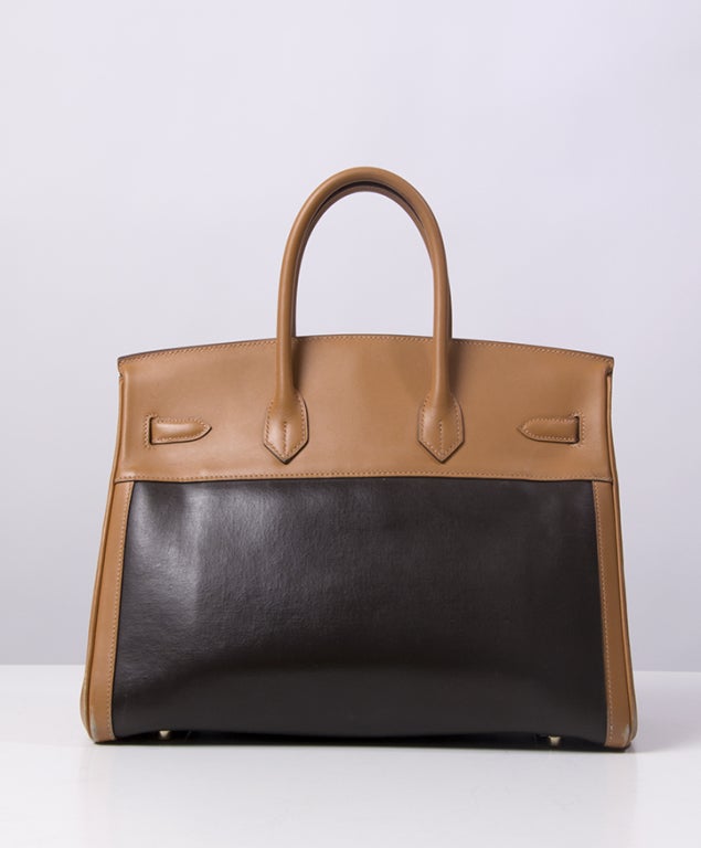 Beautiful famous HERMES BIRKIN in two tone black and beige size 35. 
The bag comes with clochette and padlock with two keys. There are two long flat pockets and protective plastic rain cover and the orange Hermes box. The hardware has very faint
