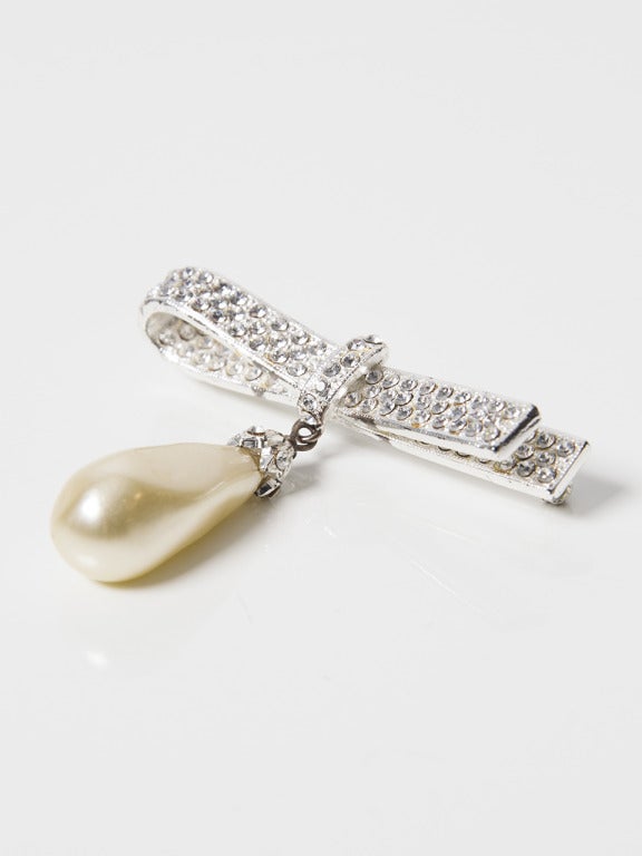 Dior Pearl And Silver Bow Brooch? Lovely silver plated bow with clear crystals and a tear shaped cream colored pearl. Stamped: 