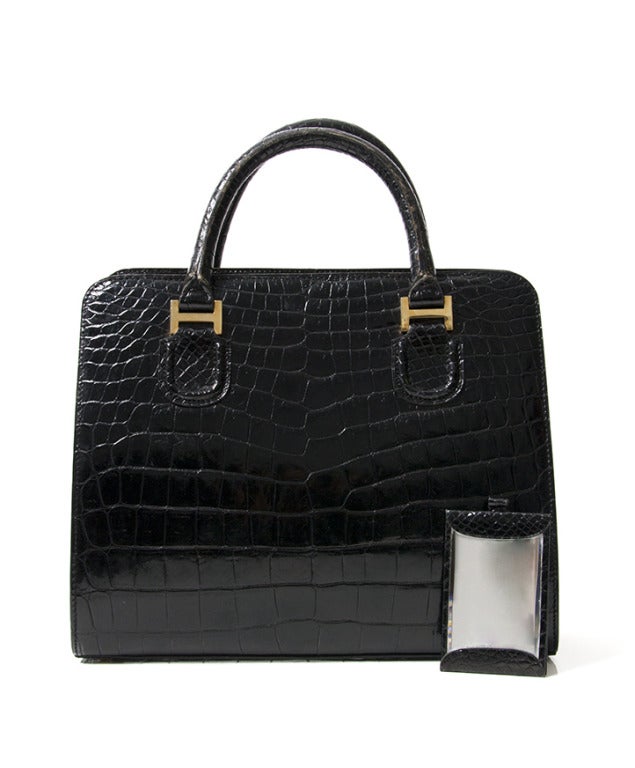 Extraordinary black Delvaux bag. Made from real polished crocodile hide. the structured shape and gold 'H' buckles on the front. The interior is very roomy: 3 separated compartments, the central one has a zipper pocket and different slots for cards