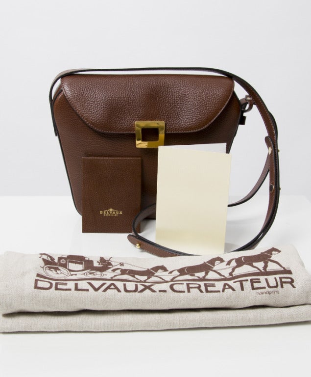 Delvaux bag made from grained calfskin. With gold press button and adjustable shoulder strap. Comes with receipt of purchase and matching pocket mirror. 

Dimensions:
7.5