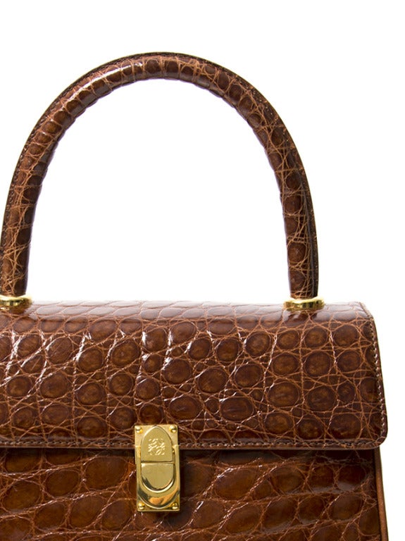 Exquisite handbag by luxury brand Loewe. Made from alligator hide in a rich cognac hue with gold hardware throughout. 

Dimension: 

8