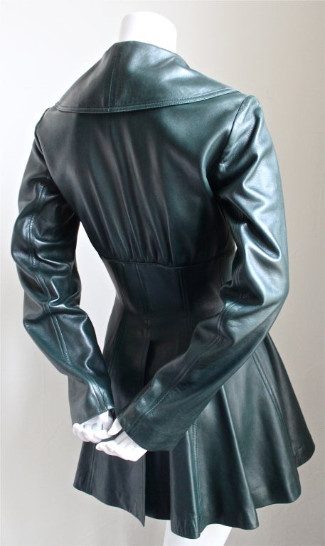 Emerald green leather coat with peplum from Azzedine Alaia dating to the late 1980's. Coat is labeled a French size 38, although it would better suit a modern day 36 based on the measurements. Approximate measurements are as follows: bust 34