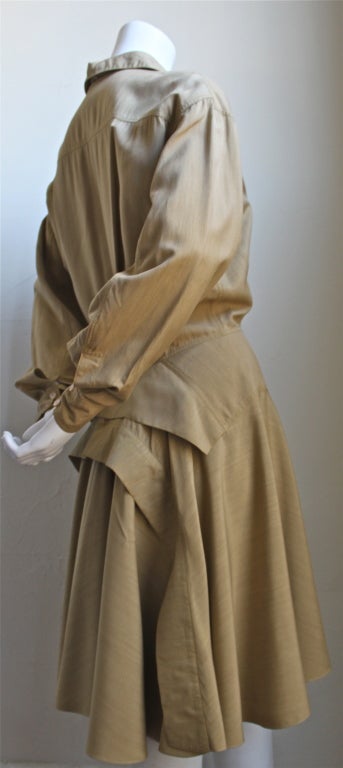 Tan shirt dress with very unique back bustle from Azzedine Alaia dating to the late 1980's. Dress best fits a US 6. Made in France. Excellent condition.