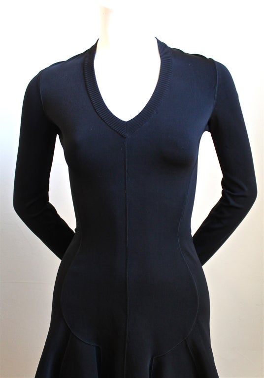 Jet black flared long sleeved mini dress designed by Azzedine Alaia dating to 1990. Labeled a size XS, although this can easily fit a size small as well. Unstretched approximate measurements are as follows: bust 30