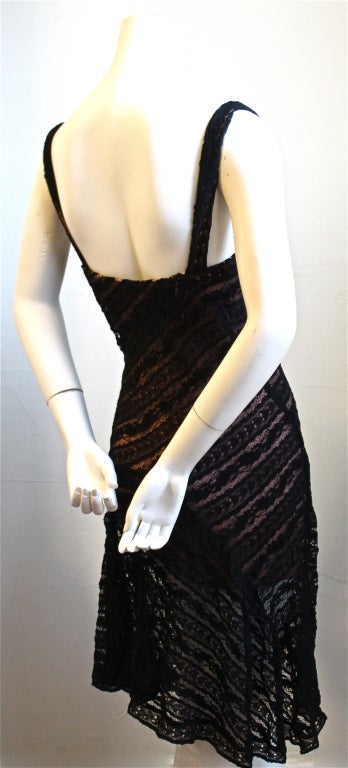 Very rare black lace dress with molded bra from Azzedine Alaia dating to spring/summer of 1993. Asymmetrically cut skirting creates a beautiful drape at the hip. French size 38. Fits an XS or S. Approximate measurements are as follows: bust 31-32