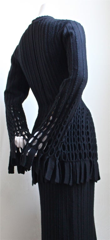 Black wool tunic and ankle length skirt with knit fringe from Azzefine Alaia dating to fall of 1987. Ensemble fits a size small or medium. Tunic can also be worn as a minidress with a slip. Tunic has a hidden zip closure at center back. Made in