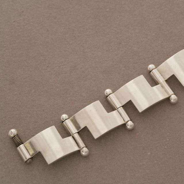 Bold modernist bracelet designed by Hans Hansen. Superb hand crafted quality with invisible screw clasp. Very heavy.