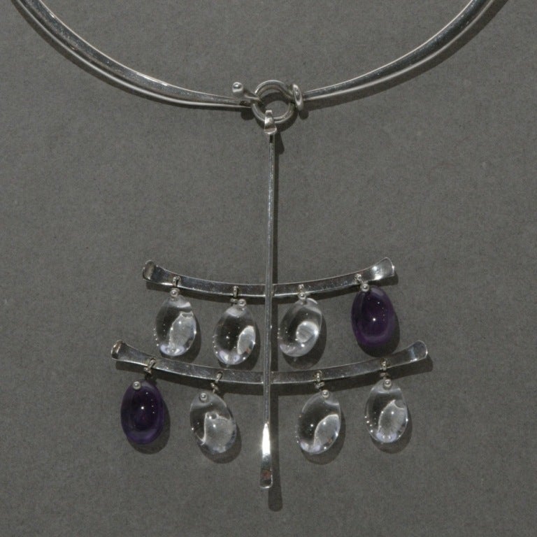 Stunning layers of clear and purple quartz drops on large pendant with hook fasten. Featured on neck ring, no. 410, 5.5 inches by 6 inches. Other neck rings available, one included in price.

Matching purple quartz drop earrings