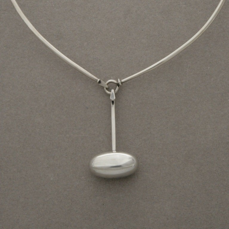 Pendant features the smooth, spherical designs that are classic of Torun's work. The pendant connects to neck ring with a sturdy sylylised hook . 
Featured on Neck Ring, no. 174, measuring 5.5