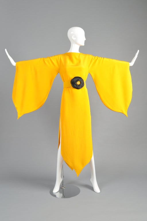 Stunning 1970s marigold colored Pierre Cardin haute couture tulip gown. Ridiculously rare find. Heavy weight rayon crepe with tulip shaped sleeves + hem. HUGE slits in each side. Also includes the matching leather-backed belt with original silk