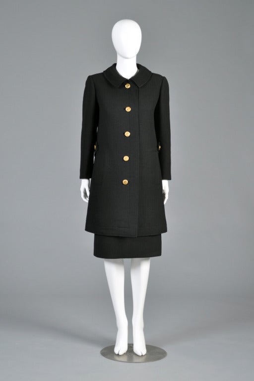 Lovely 1960s black wool Jeanne Lanvin coat + skirt. Coat features nubby wool body with gold military buttons, besom pockets, Peter Pan collar + half sash in back. High waist skirt with double metal zippers in the back. Please feel free to email for