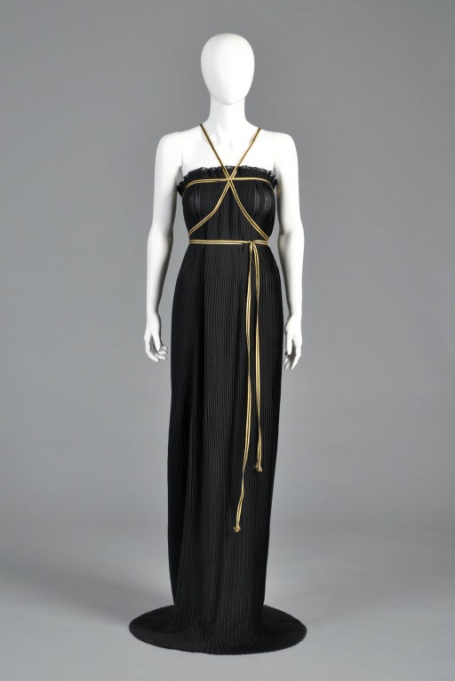Stunning 1970s Valentino Garavani pleated gown. Exceptional piece. Semi-sheer pleated voile column. Features raw edges and metallic gold + black Grecian-inspired strapping around the bodice. Many options on how to tie the straps! Slit in
