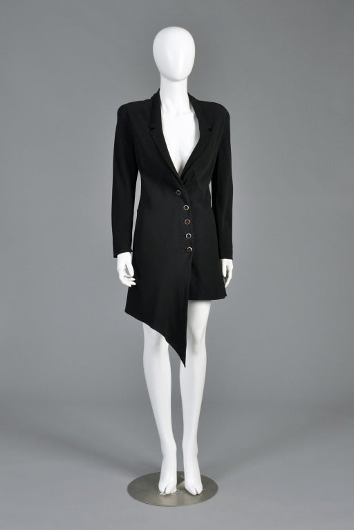 Superb 1990s Karl Lagerfeld jacket dress. Incredible avant garde construction with plunging neckline and asymmetric hem and buttons. Nice rounded shoulders + sleek arms with zippers in each cuff. Can be worn as a mini dress or jacket. Excellent