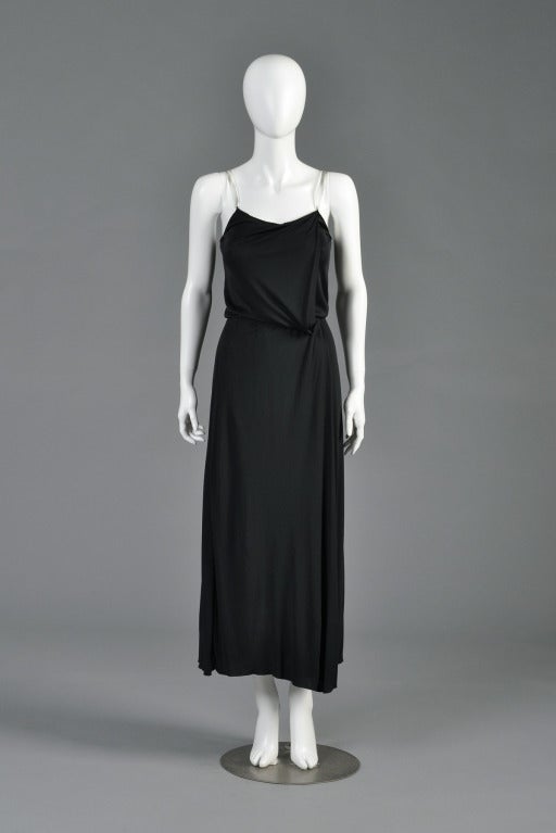 Just reduced from $895 to $495

Fabulous late 1970s evening gown by Gianni Versace for Callaghan. Draped black viscose jersey with a folded front panel + clear lucite straps. Flowing skirt + nipped elastic waist. Knit detail around the bust line.