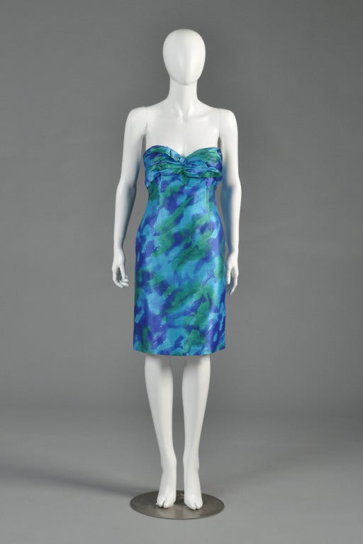 Lovely 1980s Loris Azzaro watercolor silk cocktail dress. Amazing color palette. Entirely strapless with ruched bodice + bow detail. Has built-in brassiere inside. Excellent vintage condition.

MEASUREMENTS
Bust: 33