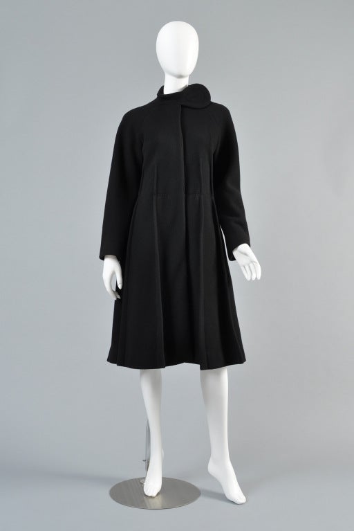 Superb 1960s black Pierre Cardin wool coat. Incredible piece. Fitted bodice with pleated, flared skirt. Long raglan cut sleeves + snapping teardrop closure at the neck. Ultimate mod coat!

Bust: 38