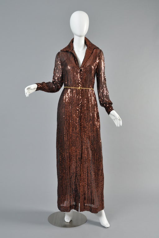 Lovely 1970s chocolatey-copper sequin evening dress. Sheer chiffon fully encrusted in sequins.  Plunging front hidden snaps + standing collar. Sheer puffed sleeves. Also includes sheer black slip. Can also be worn open as a maxi jacket.