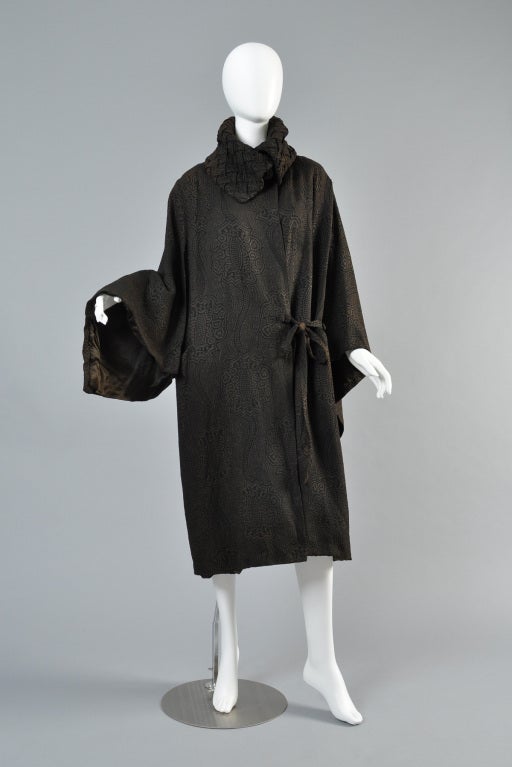 Incredible 1920s silk lamé coat. AMAZING find. Killer basket woven collar with with button closure. Huge draped sleeves. Fully lined. 

Excellent condition for a nearly 100 year old piece. There are 2 tiny tiny holes in the left sleeve that are