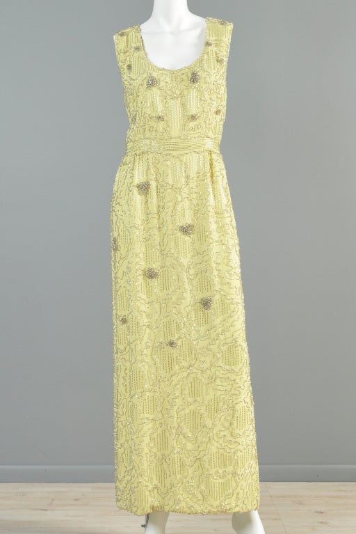 Lovely 1960s golden colored Malcolm Starr beaded gown. AMAZING piece. Scoop neck + ultra long, maxi length. Fully encrusted in metallic silver beads + rhinestones.

MEASUREMENTS
Bust: 39