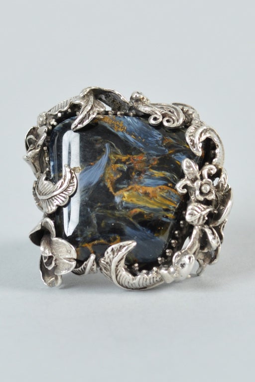 Superb Bob Stringer one of a kind hand crafted sterling floral + leaf ring. Massive polished agatized petrified wood center stone. Attention grabbing statement piece! We love the swirling colors in the stone. Size 8. Could be sized up or down by a