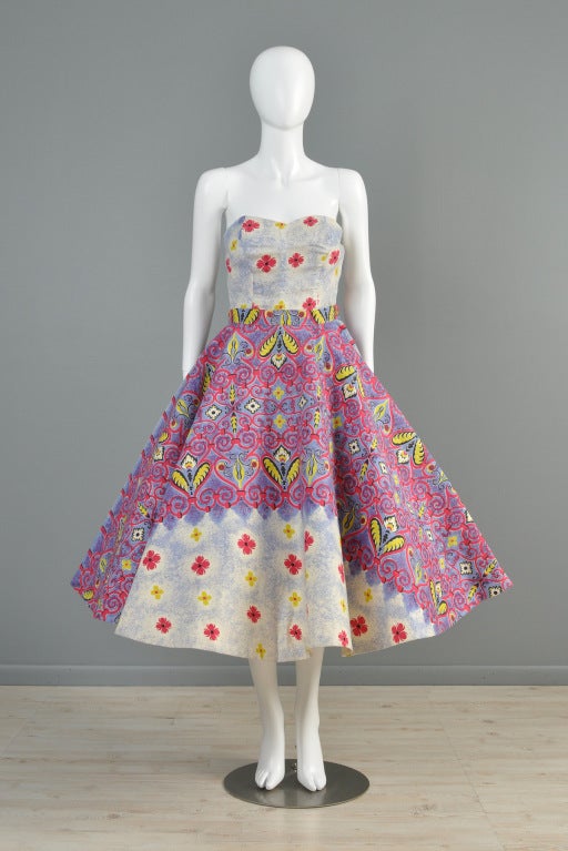 1950s 2 piece ethnic-inspired cotton patio dress. Ultra fitted bustier bodice with convertible halter/strapless option. High waisted skirt with full 360 sweep. Heavy weight interfacing on the underside of the skirt to help it keep its dramatic