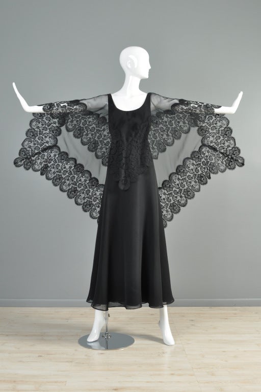 Ruben Panis 1970s/early 80s chiffon gown. Black flowy chiffon with low-scooping neckline and attached sheer scalloped lace draped cape. Plunging  back. Beautiful movement. Fully lined.