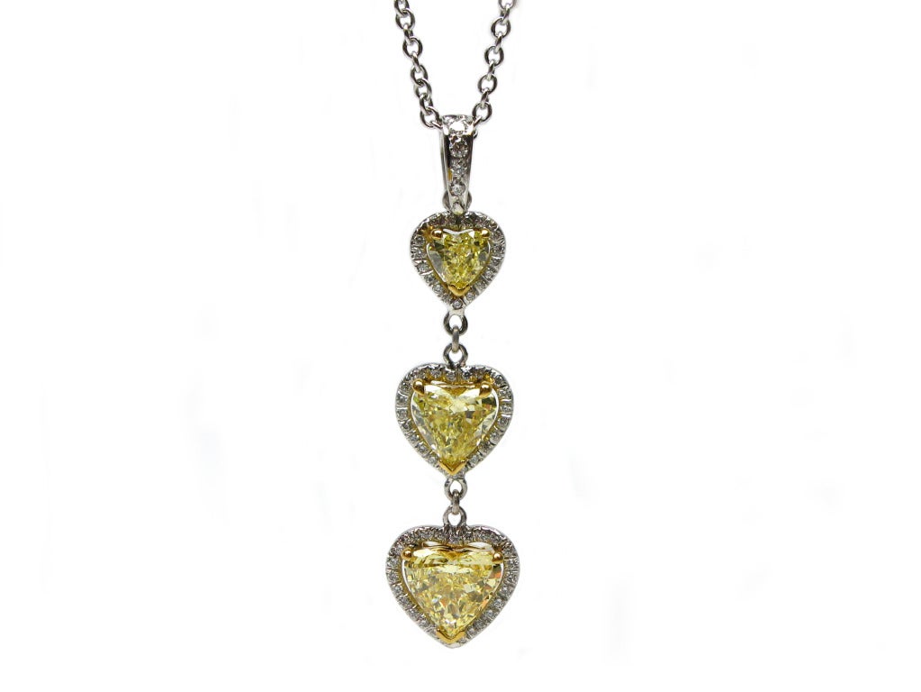 This stunning pendant is a fresh execution from J. Birnbach's Fancy Yellow Diamond collection. The piece features three fancy yellow heart-shaped diamonds, (0.40 carats, 0.84 carats and 1.07 carats), all surrounded by 0.42 carats of round diamond