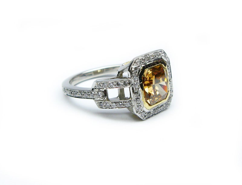 This ring is a showstopping piece from the J. Birnbach colorful diamond collection. This unique GIA-certified 2.01 carat natural fancy deep brownish yellow color radiant diamond is set in platinum with an 18kt yellow gold bezel. It is surrounded by