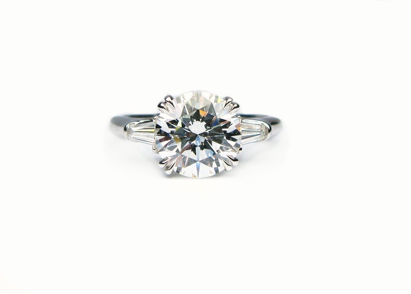 This exquisite 2.34ct F color VS1 clarity round brilliant diamond is set in a Harry Winston signed platinum band with tapered baguette side stones. This ring is pure perfection and will make any woman sparkle.