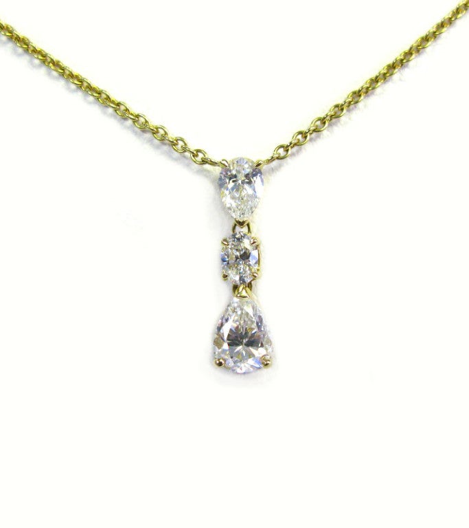 This 18 karat yellow gold pendant, features two pear shape and one oval, I color, SI quality diamonds, with a total carat weight of 1.85. The simple elegance of this piece is ideal for everyday wear, or use it to dress up your favorite little black