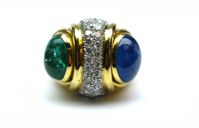 David Webb Cocktail Ring with a cabochon sapphire and a cabochon emerald flanking a center pavement of white diamonds. Signed 