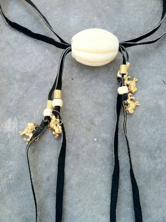 A rare vintage William de Lillo leather neck piece. Signed long leather strip item threaded thru a large carved ivory glass bead with attached matching beads and gilt lions.

Rare item from the William de Lillo archives.

William de Lillo
