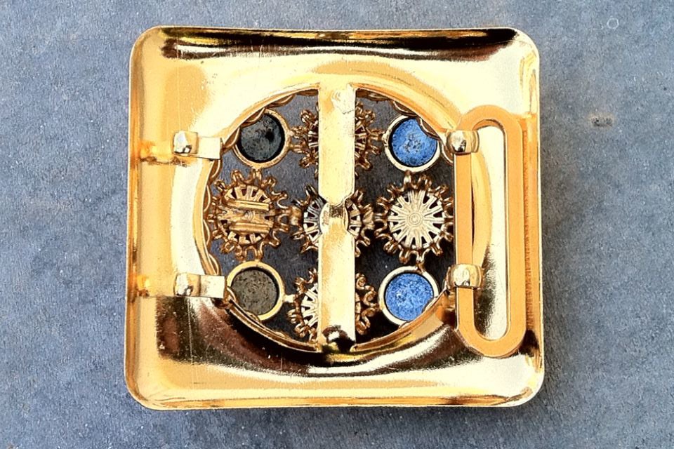 A rare vintage William de Lillo 'jeweled' belt buckle. Signed gilt metal item features art glass 'jewels' and hematite cabochon stones. Note back hooks appropriate for a custom belt i.e. silk, leather etc.

Rare item from the William de Lillo