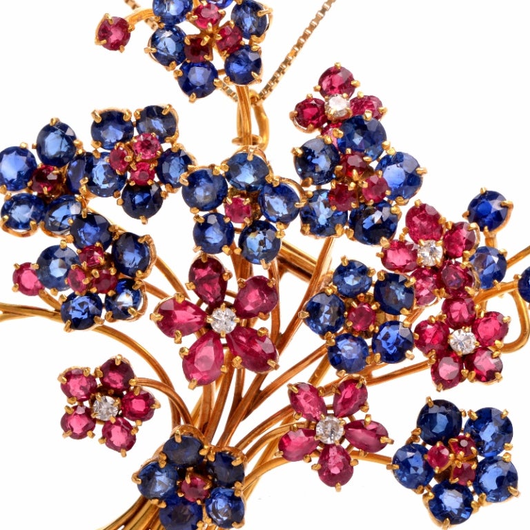 Nothing quite as beautiful and joyful as a bouquet of flowers, this stunning pendant French pin is sure to add wonderful color to any ensemble. Finely crafted in solid 18K yellow gold, this pin features a floral bouquet design that is accented with