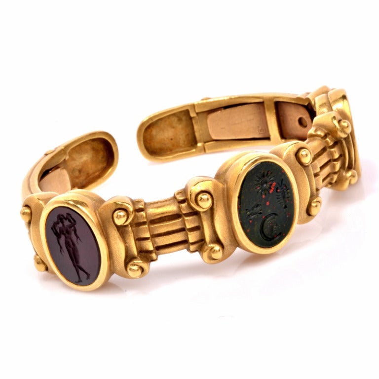 This is a striking Barry Kieselstein-Cord intaglio bracelet, rich in detail and made of exquisite materials. This bracelet is crafted in solid 18K yellow gold . It's design features three columns and stations and glass intaglio cabochons. This