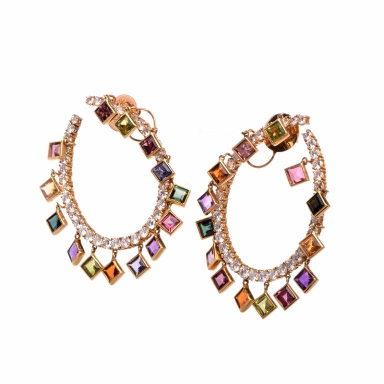 These dazzling earrings are simply gorgeous, adding rich tones and eye-catching sparkle to any ensemble. Finely crafted in solid 18K yellow gold, these earrings feature a gentle curve hoop that is set with a shining row of 78 genuine round cut