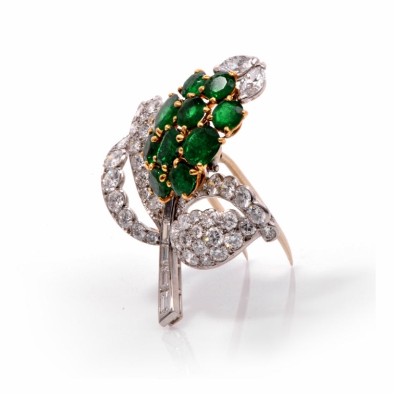 This exquisite designer Cartier vintage brooch pin fine crafted in solid Platinum and 18K yellow gold. This dazzling pin features a floral design, set with 10 genuine round and oval cut Emeralds approx: 8.10 carats, prong set in 18K yellow gold. The