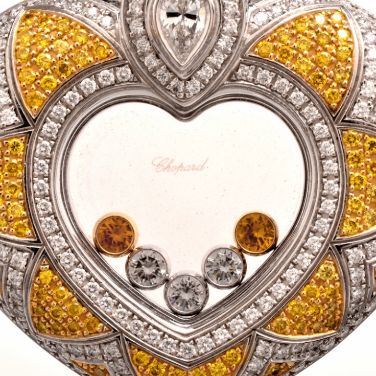 This alluringly beautiful Chopard pendant of romantic inspiration is crafted in solid 18K white gold , while  yellow gold has been  applied to fancy  diamond prong settings. This artfully designed romantic piece of jewelry exposes a genuine