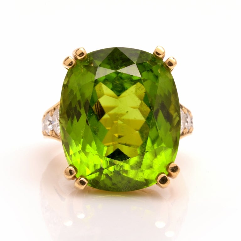 This alluring estate certified peridot and diamond cocktail ring of attention-seeking beauty is crafted in solid 18K yellow gold weighing 5.7 grams.  This exquisite ring exposes a rare, cushion brilliant cut GIA certified peridot gem of the highly