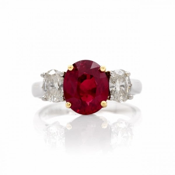 This rare estate ruby and diamond engagement ring of classic elegance is crafted in platinum, with 18K yellow gold applied to the setting of the center stone. This alluring engagement ring of remarkable feminine appeal exposes at the center a high