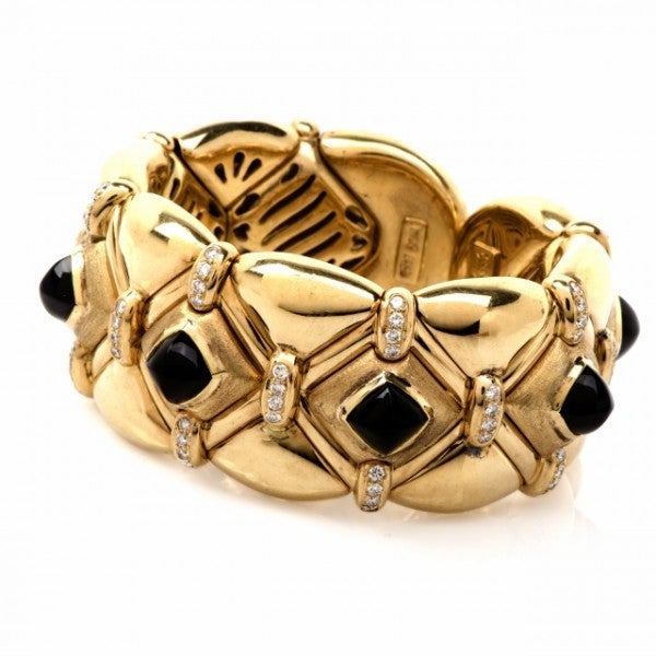 This vintage Italian Retro cuff bracelet with diamonds and black onyx is in solid 18K yellow gold, a combination of polished and matted. It is adorned with carved onyx 'pyramids' at the center approx: 7mm x 7mm, approx. 14.35cttw and enriched with a