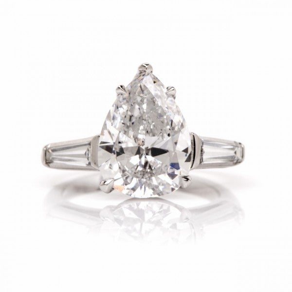This exquisite vintage 1950's platinum engagement ring with a significant 3.19ct GIA certified pear-shaped diamond and a pair of tapering baguette diamonds is crafted in solid platinum and weighs approx. 5.5 grams. The eye-catching 3.19ct
