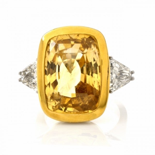 This arresting estate ring with a significant, AGL certified genuine yellow sapphire and  triangular-cut diamonds is crafted in combined solid Platinum and 18K yellow and weighs approx. 24.9 grams. Designed with elegant simplicity, this captivating