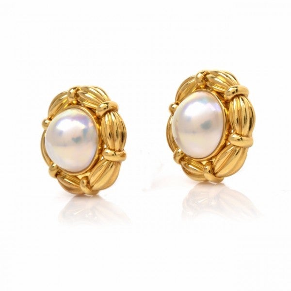 These estate authentic Tiffany & Co. earrings are crafted in solid 18K yellow gold, weigh approximately 30.4 grams. In alluring floral design, these earrings are centered with a duo of iridescent Mabe pearls, measuring approx. 30mm in diameter of a