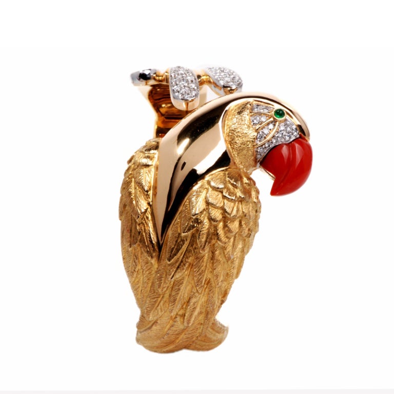 This stunning estate cuff bracelet is crafted in solid 18K yellow gold. This magnificent heavy piece displays the image of a parrot bird  with a extremely fine detailed carving of its body and feathers. This bracelet is accented with 77 genuine