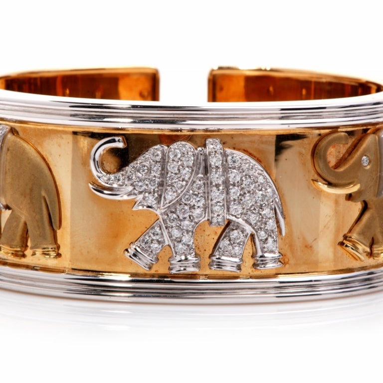 This beautiful and exquisite and heavy wide cuff bracelet is crafted in solid 18K yellow gold. This charming bracelet features 3 handcrafted elephants topped on a  high polish wide gold bangle  with 83 round cut diamonds approx. 2.50 ct,G-H 