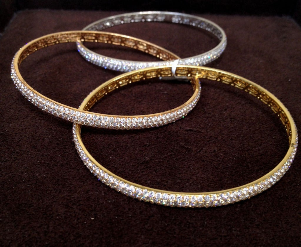 A beautiful sparkly bangle bracelet. 

18k rose, yellow and white gold pave diamond bangles interlocked and set with 24.50 carats of F-G color round brilliant cut diamonds.

This bangle fits a size 8 inch wrist.